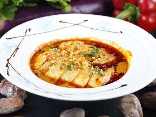 a white plate with a bowl of food on a table at Pullman Xiamen Powerlong in Xiamen