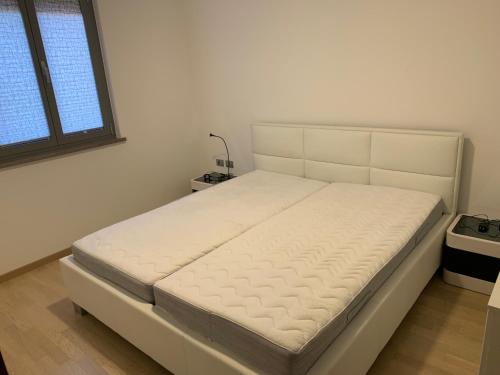 białe łóżko w pokoju z oknem w obiekcie Ankaran apartments w Ankaranie