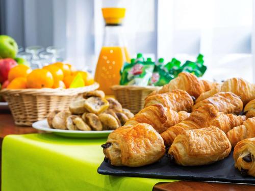 a table with croissants and other pastries and fruit at Ibis Styles Reims Centre in Reims