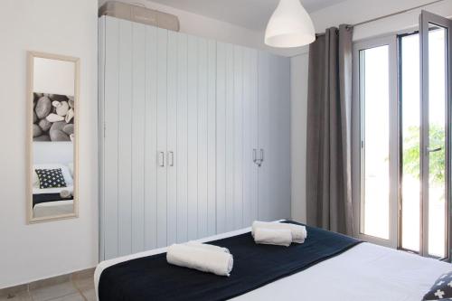 a bedroom with a bed with two towels on it at Kea Villa Thea- Villa Ilios in Vourkarion
