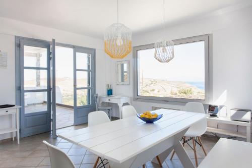 a white dining room with a white table and chairs at Kea Villa Thea- Villa Ilios in Vourkarion