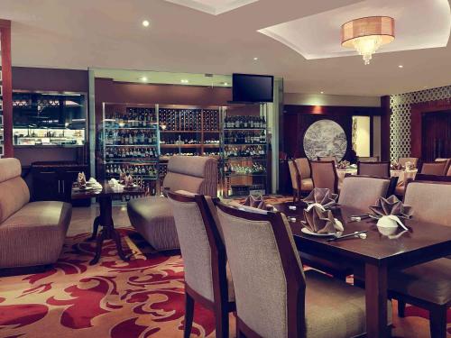a dining room with a table and chairs at Grand Mercure Bandung Setiabudi in Bandung