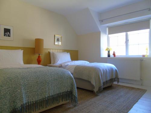 a bedroom with two beds and a window at Thistle Cottage, CrannachCottages in Garve