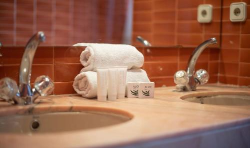 卡拉费尔Villa tennis park with air conditionner的浴室水槽上堆着的毛巾