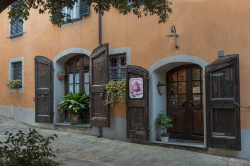 an orange building with wooden doors and potted plants at Antica Casa Dei Rassicurati in Montecarlo