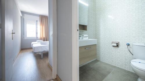 une salle de bains blanche avec toilettes et lavabo dans l'établissement R68 Apartamento Montserrat 32-3, à Calafell