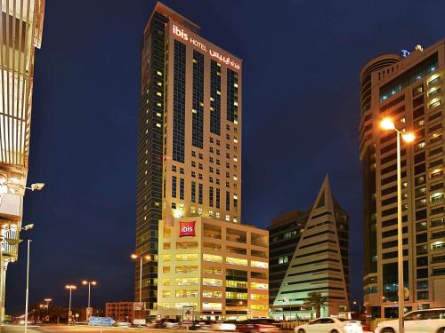 a city street with tall buildings and a clock tower at ibis Seef Manama in Manama