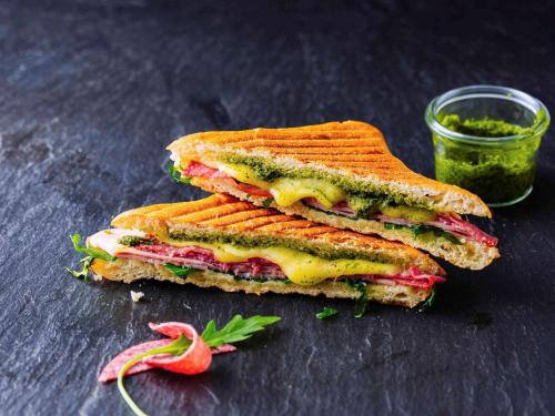 a sandwich cut in half next to a jar of mustard at ibis Lille Centre Grand Palais in Lille