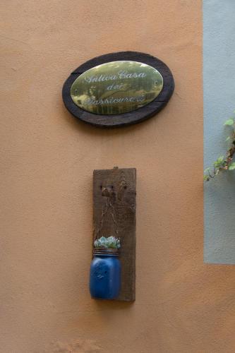 a sign on a wall with a blue pot on it at Antica Casa Dei Rassicurati in Montecarlo