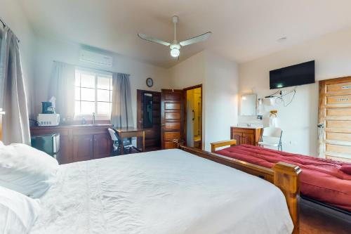 ein Schlafzimmer mit einem großen Bett und einem roten Sofa in der Unterkunft Isebei Guest House in Hopkins