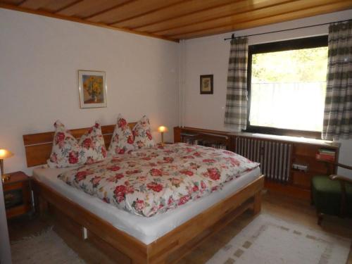 a bedroom with a large bed with red flowers on it at Apartment Gerlitzen Ossiachersee - Haus Enzian in Treffen