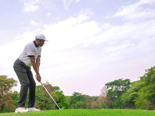 a man is playing golf on a field at Pullman Lubumbashi Grand Karavia. in Lubumbashi
