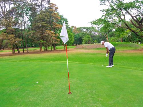 a man is playing golf on a golf course at Pullman Lubumbashi Grand Karavia. in Lubumbashi