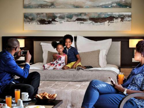 a group of people sitting on a bed at Pullman Lubumbashi Grand Karavia. in Lubumbashi
