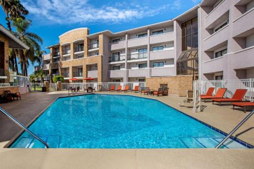 uma piscina em frente a um edifício de apartamentos em La Quinta by Wyndham Pomona em Pomona