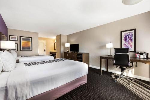 a hotel room with a large bed and a desk at La Quinta by Wyndham Pomona in Pomona