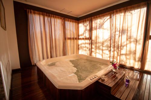 a bath tub in a room with a window at Hathor Concordia in Concordia