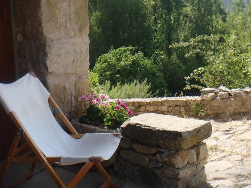 a white chair sitting next to a stone wall at La Casa de Los Moyas in Olba