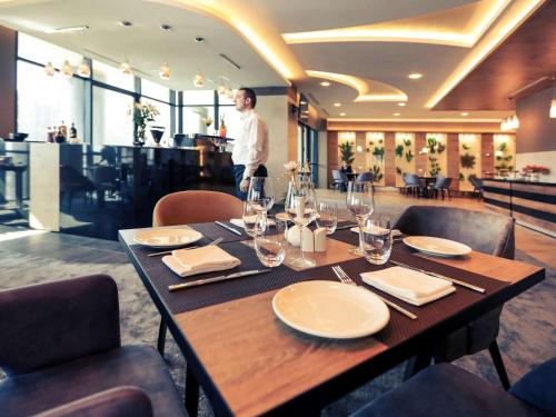 a man standing behind a table in a restaurant at Mercure Tetovo in Tetovo