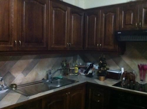 a kitchen with wooden cabinets and a kitchen sink at Zakos Court Apartments in Larnaca