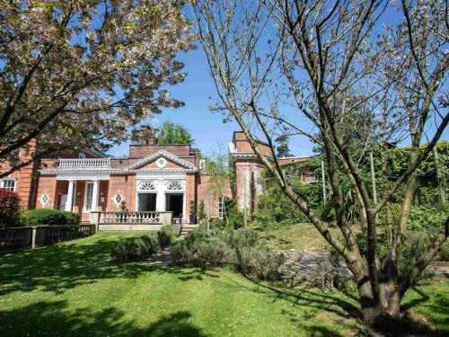 an exterior view of a house with a yard at Hunton Park Hotel in Kings Langley