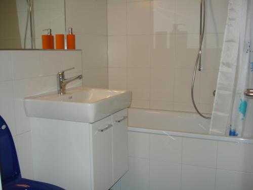 a white bathroom with a sink and a shower at Chalet Viola in Wengen
