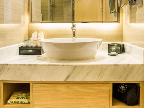 La salle de bains est pourvue d'un lavabo et d'un comptoir. dans l'établissement ibis Styles Changsha Intl Exhibition Ctr, à Huangxing