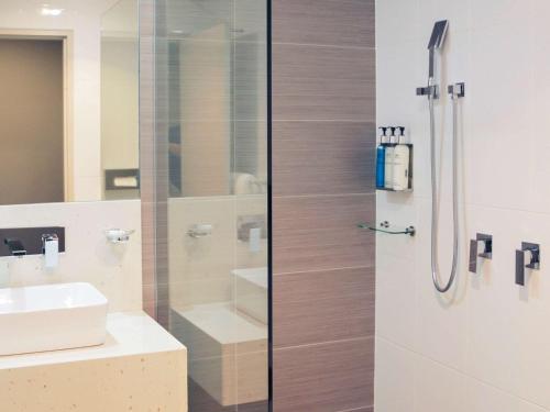 a bathroom with a shower and a sink at Mercure Orange in Orange