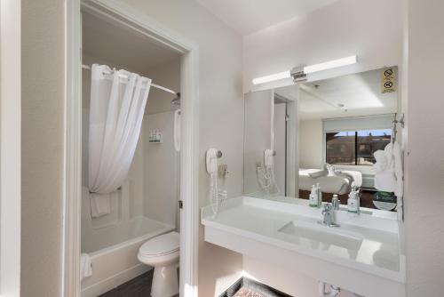 uma casa de banho com um lavatório, um WC e um espelho. em GreenTree Inn Sedona em Sedona