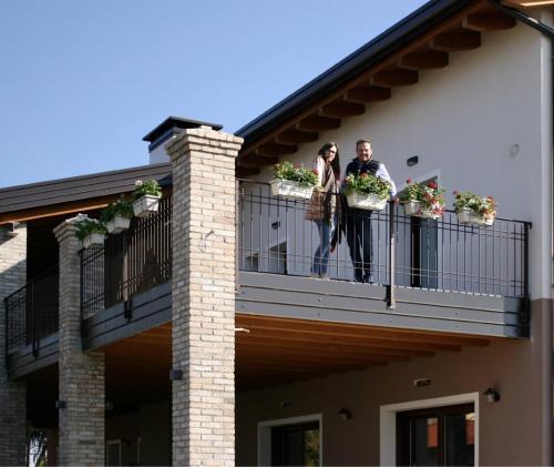 two people standing on a balcony of a house at Agriturismo Casale ai Prati in Latisana