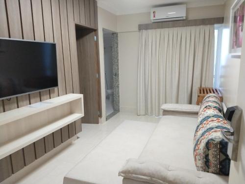 a living room with a couch and a flat screen tv at Piazza diRoma - Apartamentos JN in Caldas Novas