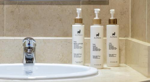 three bottles ofodorizers sitting next to a bathroom sink at Río Serrano Hotel + Spa in Torres del Paine