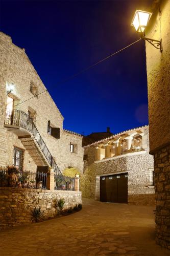 a building with a garage and a street light at Cal Carulla in L'Astor