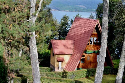 una pequeña casa con techo rojo en el bosque en Zirahuen Forest and Resort, en Zirahuén
