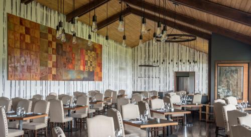 a dining room with tables and white chairs at Río Serrano Hotel + Spa in Torres del Paine