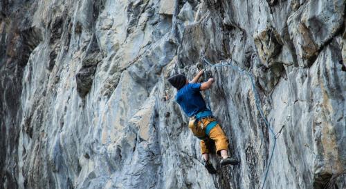 a man is climbing on a rock wall at Río Serrano Hotel + Spa in Torres del Paine