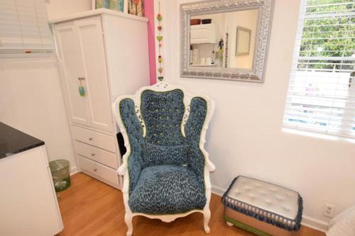 a living room with a chair and a mirror at Beverly Hills Celebrity Home in Los Angeles