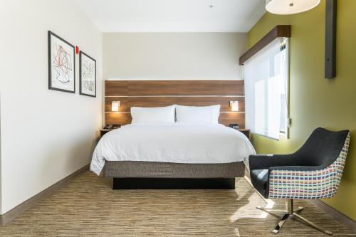 Habitación de hotel con cama y silla en Holiday Inn Express San Clemente N – Beach Area, an IHG Hotel en San Clemente