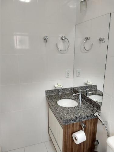 a bathroom with two sinks and a mirror at Lacqua diRoma 1 - Apartamentos JN in Caldas Novas