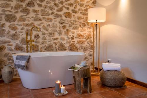 a bath tub in a bathroom with a stone wall at La Collina dei Nebrodi in San Marco dʼAlunzio