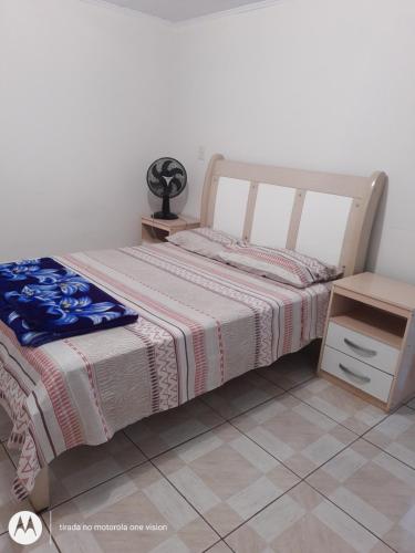 a bedroom with a bed and a night stand at Edícula. Ent.independente in Sorocaba