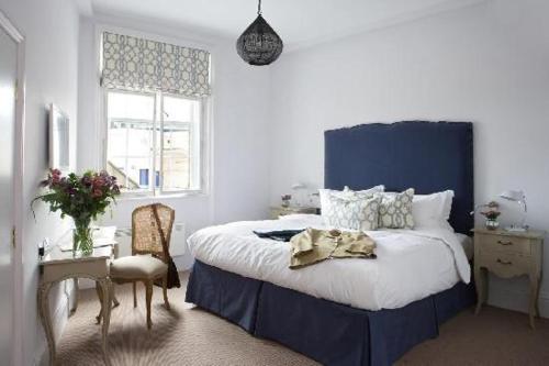 a bedroom with a large bed with a blue headboard at Rooms by Bistrot Pierre at The Crescent Inn in Ilkley