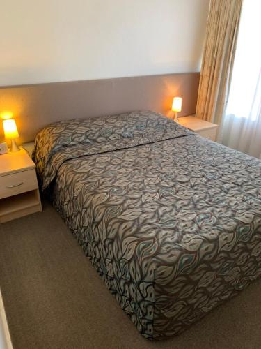 
a hotel room with a bed and a lamp at Shellharbour Resort and Conference Centre in Shellharbour
