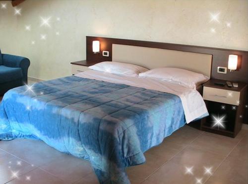 a bedroom with a large bed with a blue blanket at B&B Suite in Viagrande