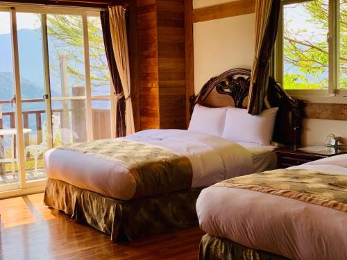 two beds in a room with a balcony at The Cotswolds Villa in Renai