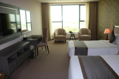 a hotel room with two beds and a flat screen tv at Muong Thanh Luxury Can Tho Hotel in Can Tho