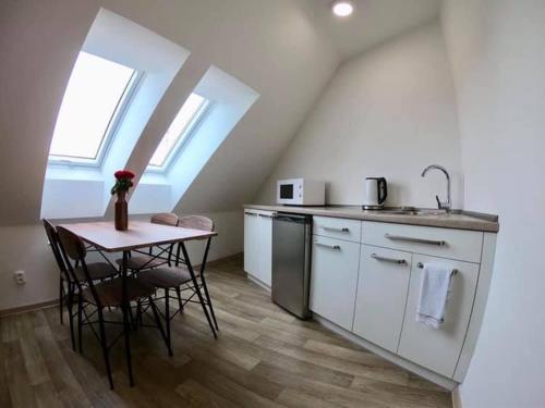 a kitchen with a small table and a sink at Rodinný Penzion Kyjov in Kyjov