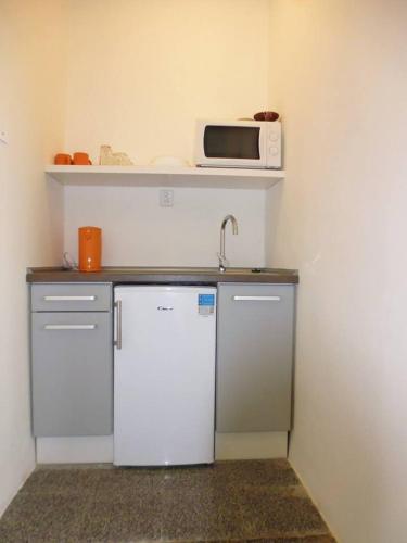 a kitchen with a refrigerator and a microwave on a shelf at Rodinný Penzion Kyjov in Kyjov