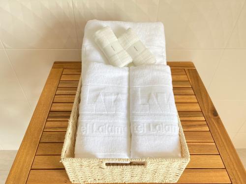 a basket of towels sitting on a wooden table at Lalamare Kouri in Nakijin