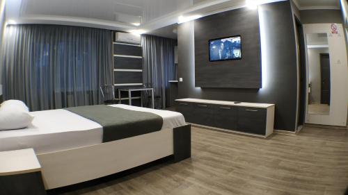 a hotel room with a bed and a flat screen tv at Двухкомнатный люкс центр Металлургов 19 KR Apartments in Kryvyi Rih